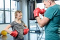 Preteen girl boxing with senior trainer