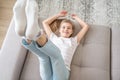 Preteen girl lying on couch with her feet raising up high Royalty Free Stock Photo