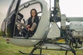 Preteen girl in mirrored sunglasses sitting in open helicopter cockpit