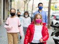 Preteen girl in pink protective mask walking outdoors