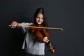 Preteen girl playing violin on black background Royalty Free Stock Photo