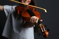 Preteen girl playing violin on black background, closeup Royalty Free Stock Photo