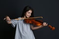 Preteen girl playing violin on black background Royalty Free Stock Photo