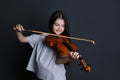 Preteen girl playing violin on black background Royalty Free Stock Photo