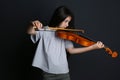 Preteen girl playing violin on black background Royalty Free Stock Photo