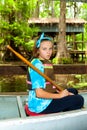 PreTeen Girl Sits in a Metal Canoe Ready to Launch with Paddle i