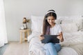 Preteen girl wear headphones using modern digital tablet at home Royalty Free Stock Photo