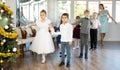 Preteen girls and boys performing curtsy and bow during festive dance event