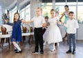 Preteen girls and boys performing curtsy and bow during festive dance event