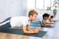 preteen girls and boys together in yoga pose upward facing dog at gym