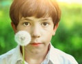 Preteen handsome boy blow with dandelion Royalty Free Stock Photo