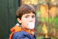 Preteen handsome boy with chewing gum bubble close up counrty po Royalty Free Stock Photo