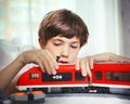 Preteen handsome boy play with meccano toy train and railway sta