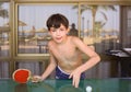 Preteen handsome boy play table tennis in the beach resort hotel