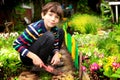 Preteen handsome boy work in the blossoming summer garden