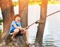 Preteen happy boy fishing on the lake close up