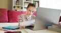 Preteen schoolgirl doing her homework with laptop computer at home. Child using gadgets to study. Online education and distance Royalty Free Stock Photo