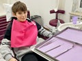 Preteen young boy visiting dentist, having his teeth checked by dentist in dental office. Happy teenager without fear. Royalty Free Stock Photo