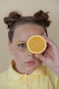 preteenager girl with lemon on yellow background. child with fruit