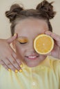 preteenager girl with lemon on yellow background. child with fruit