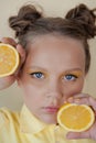 preteenager girl with lemon on yellow background. child with fruit