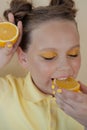 preteenager girl with lemon on yellow background. child with fruit