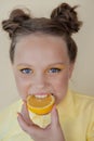 preteenager girl with lemon on yellow background. child with fruit