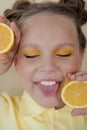 preteenager girl with lemon on yellow background. child with fruit