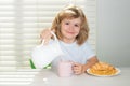 Pretten child pouring whole cows milk. Kid boy eating healthy food vegetables. Breakfast with milk, fruits and Royalty Free Stock Photo