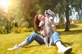 Pretty adult caucasian happy woman resting in the park on a sunny day with her beloved dog. Female lies on the grass, smiling and Royalty Free Stock Photo