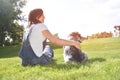 Pretty adult caucasian happy woman resting in the park on a sunny day with her beloved dog. happy caucasian woman hugs her beloved Royalty Free Stock Photo