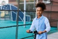 Pretty African American adolescent girl with electric scooter