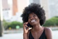 A pretty African american business woman talking on a cell phone at office building in the city Royalty Free Stock Photo