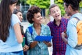 Pretty african american exchange student talking with latin and hispanic young adults Royalty Free Stock Photo