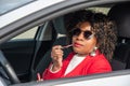 Pretty african american woman in a car doing makeup while standing in a traffic Royalty Free Stock Photo