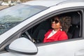 Pretty african american woman in a car doing makeup while standing in a traffic Royalty Free Stock Photo