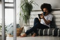 Pretty African American young woman reading an eBook at home Royalty Free Stock Photo