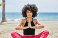 Pretty afro american woman meditating on beach Royalty Free Stock Photo