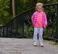 pretty angry upset beautiful little girl pink clothes posing park alley autumn Royalty Free Stock Photo