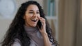 Pretty arabian smiling girl young lady talk by mobile phone enjoy wireless conversation tell gossip shocked joyful happy Royalty Free Stock Photo