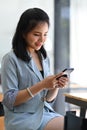 Pretty businesswoman sitting in office and using smart phone. Royalty Free Stock Photo