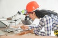 Pretty Asian carpenter woman is marking on wood. Royalty Free Stock Photo