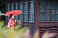 Young, beautiful and elegant Chinese woman wearing a typical Chinese bride`s silk red dress, adorned with golden phoenix and drago Royalty Free Stock Photo