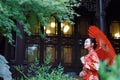 Young, beautiful and elegant Chinese woman wearing a typical Chinese bride`s silk red dress, adorned with golden phoenix and drago Royalty Free Stock Photo