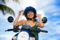 Pretty Asian Chinese girl showing key of new motorbike wearing motorcycle safety helmet smiling proud in scooter buying and rental Royalty Free Stock Photo