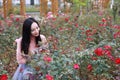 Pretty Asian Chinese woman beautiful girl outdoor sit around flowers rose park garden feel carefree caucasian pasttime read book Royalty Free Stock Photo