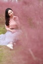 Pretty Asian Chinese woman beautiful girl outdoor sit on grass lawn in a park garden feel carefree caucasian pasttime read book Royalty Free Stock Photo