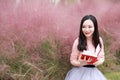 Pretty Asian Chinese woman beautiful girl outdoor sit on grass lawn in a park garden feel carefree caucasian pasttime read book Royalty Free Stock Photo