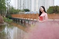 Pretty Asian Chinese woman beautiful girl outdoor sit on grass lawn in a park garden feel carefree caucasian pasttime read book Royalty Free Stock Photo