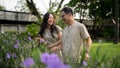 A pretty Asian daughter and her dad are enjoying talking while strolling in their courtyard garden